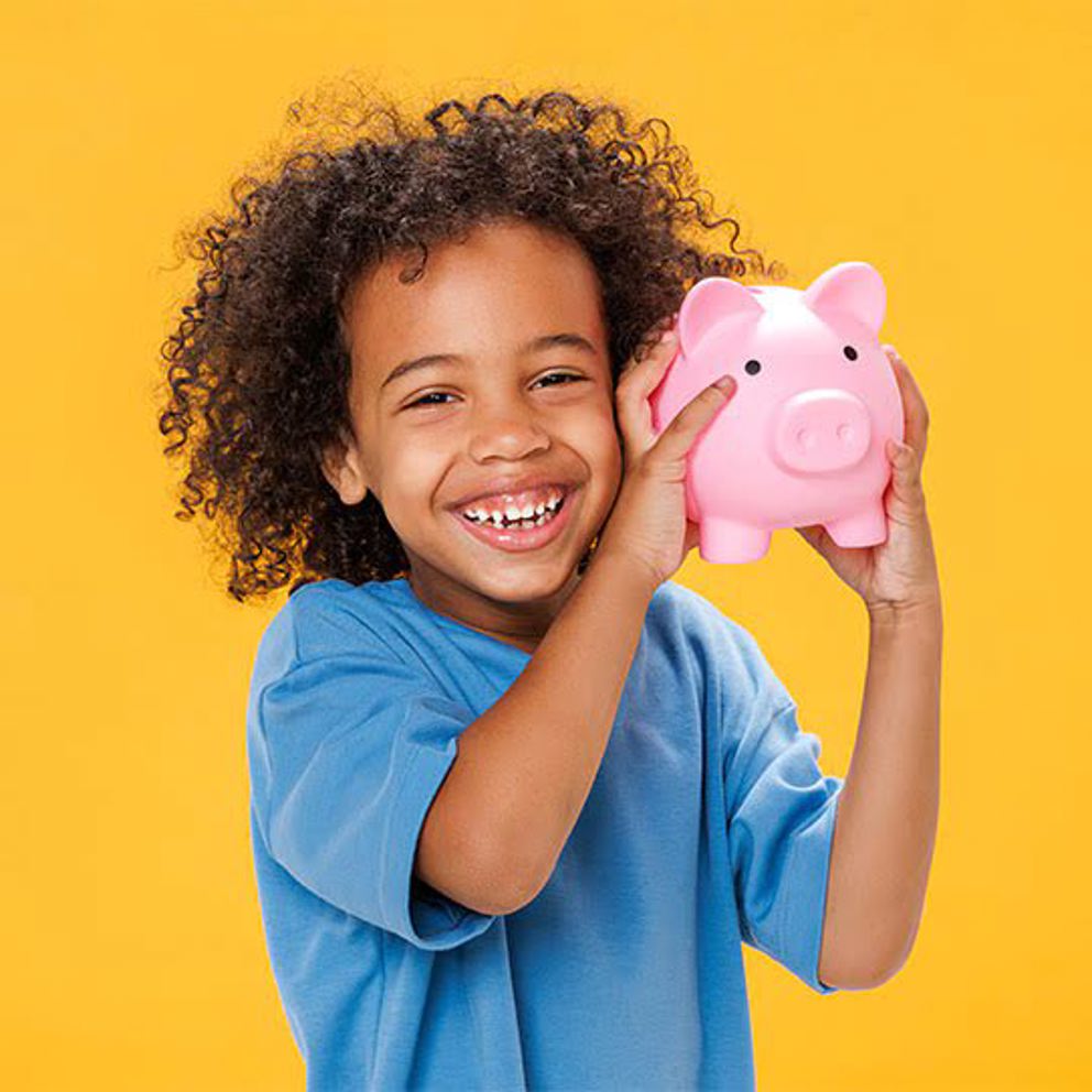 A boy holding a piggy bank with a yellow background