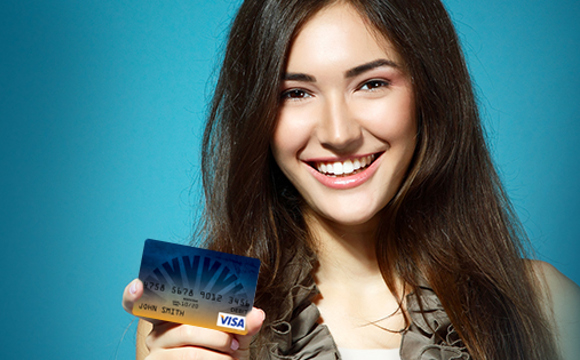 A smiling women holding a Weber State Credit Union reloadable card.