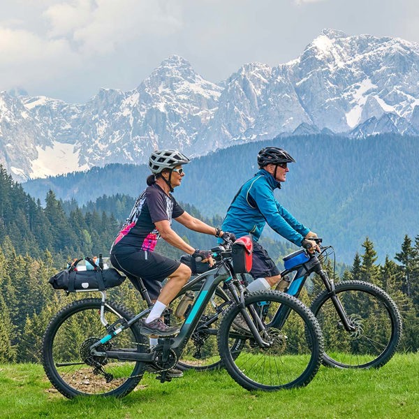 A couple riding E-bikes together in the mountains