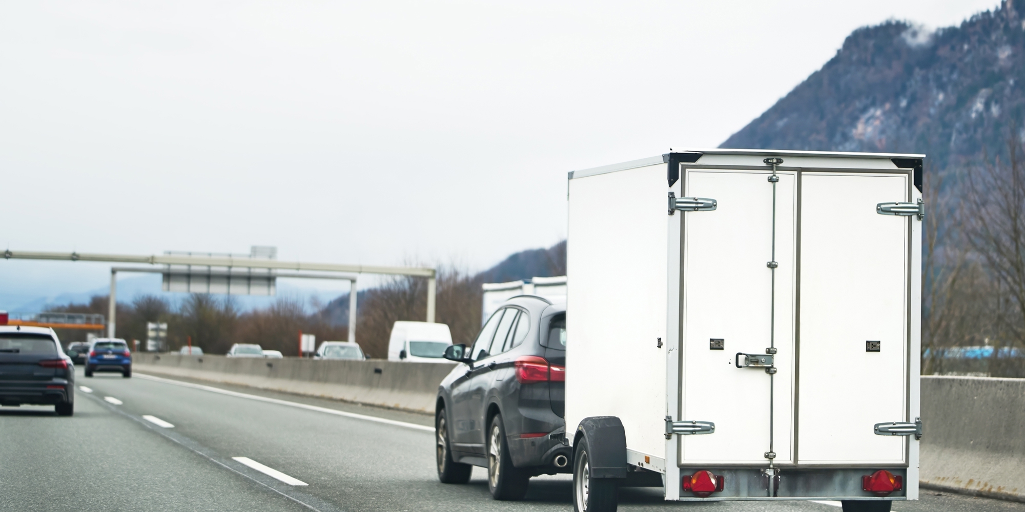 A small utility trailer being pulled by an SUV