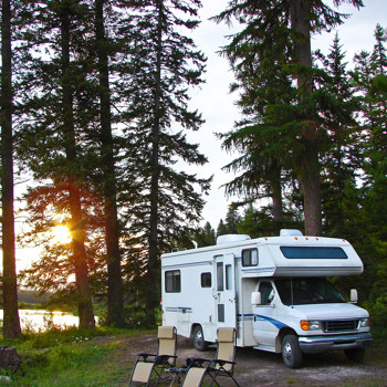 Camper parked with two lawn chairs out in front