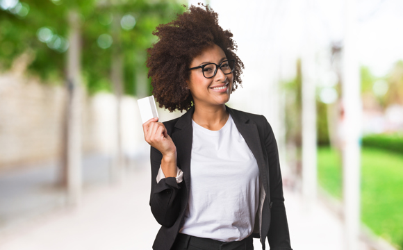 A women wearing a blazer holding a Weber State Credit Union Business Credit Card