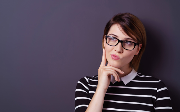 A woman in glasses deep in thought