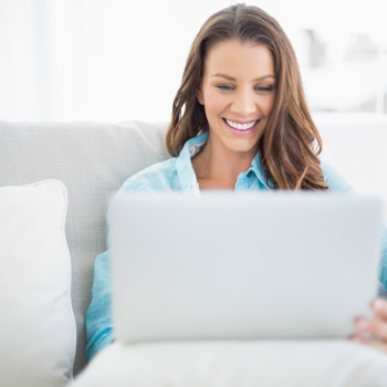 Women smiling while looking at her laptop