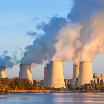 Steam coming out of large industrial smokestacks