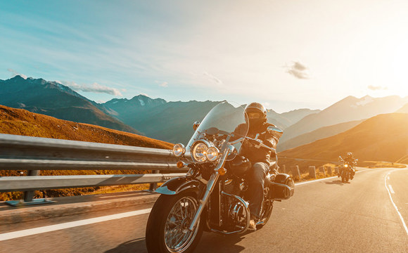 Two motorcycles driving up a canyon.