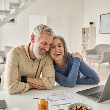 An older couple looking at a laptop.