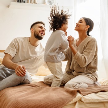 A young family jumping on the bed