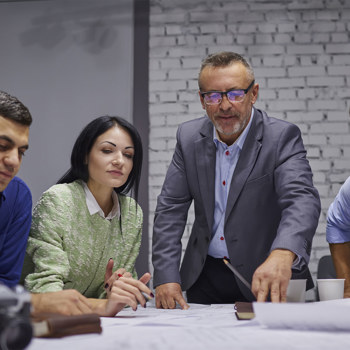 Professionals closely interacting over some design documents.