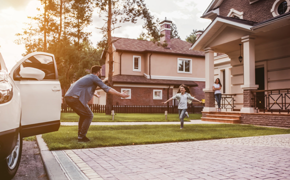 A daughter running to hug her dad who just arrived home.